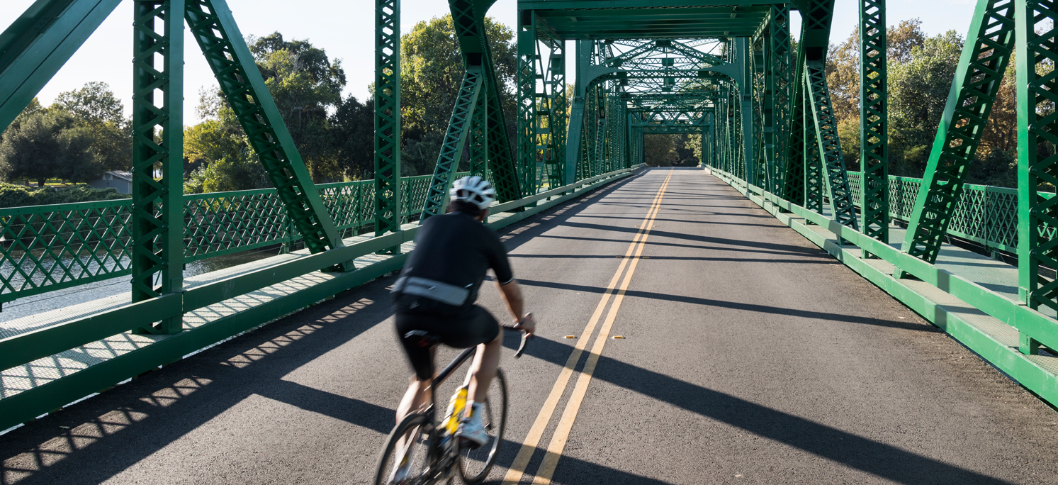 Photo of Man Biking on Bridge